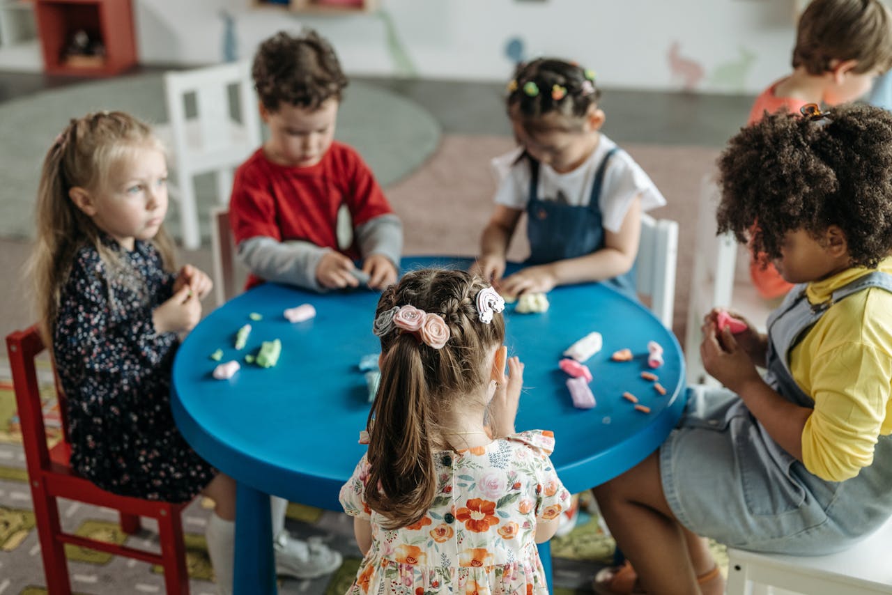 Crafting Captivating Headlines: Your awesome post title goes here Group of preschool children playing with clay at a colorful table in a classroom.